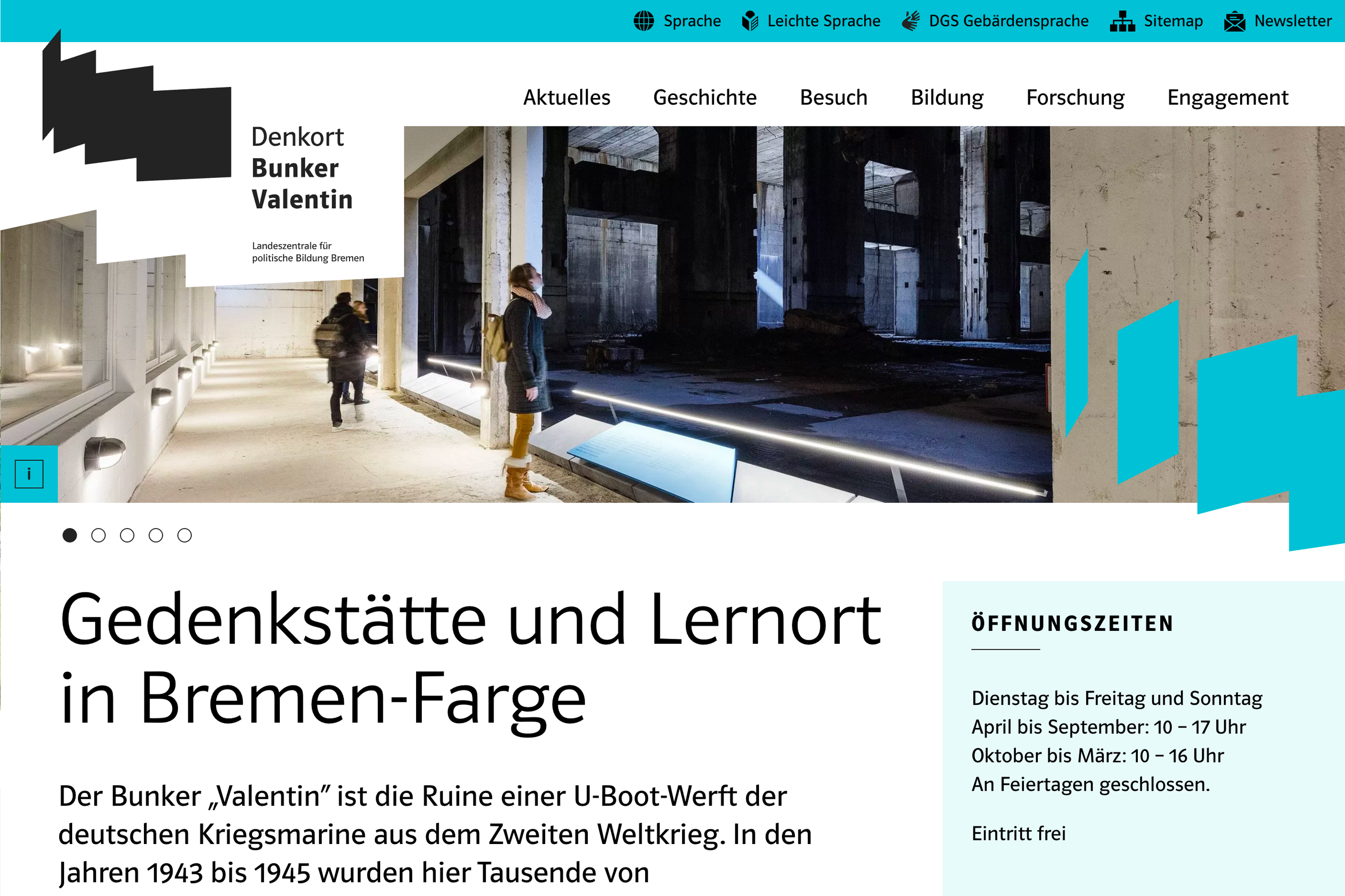 Der Innenraum eines historischen Bunkers mit beleuchteten, grauen Wänden und Besuchern, die sich umsehen. Ziel ist die Wahrnehmung der Geschichte.